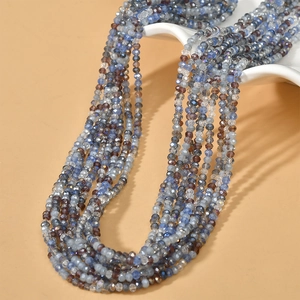 Detail shot of 3mm faceted blue and brown crystal beads on a professional beige display