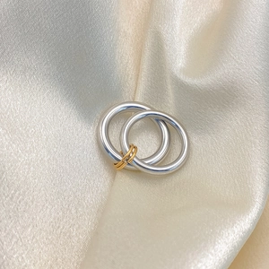Detail of elegant two-tone interlocking rings on premium silk fabric background