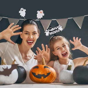 Mutter und Tochter mit Halloween-Haarbändern mit Geistern und Happy Halloween Text