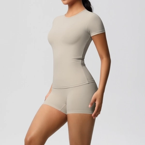 Detail of high-stretch beige yoga set featuring a slim-fit T-shirt and high-waist shorts