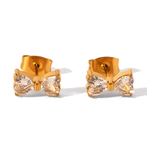 Dettaglio macro di orecchini a fiocco in oro 18K con zirconi a forma di cuore