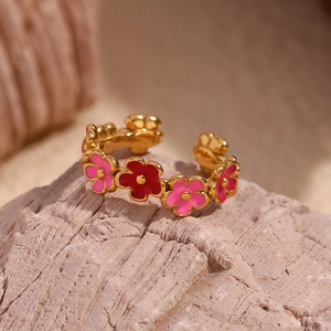 Detail of 18K gold plated adjustable ring with pink and red enamel flower patterns