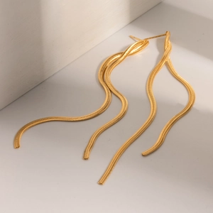 Detailed view of golden snake chain tassel earrings with glossy metallic finish