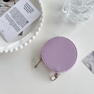 Detail of round lavender lychee leather coin purse with silver zipper and metal hook