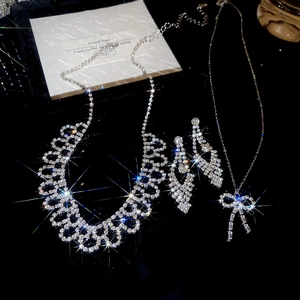 Macro shot of silver bow jewelry set with shimmering zircons and layered necklace