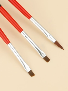 Macro detail of three professional nail art brushes with round, flat, and angled tips