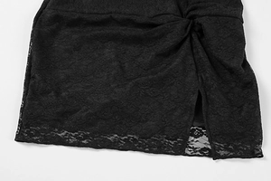 Détail d'une robe en dentelle noire avec motifs floraux, fente latérale et plissage