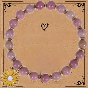 Detail of pink zebra jasper beaded bracelet with a yellow sunflower enamel charm on card