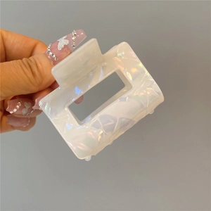 Detailed view of iridescent white acetate shark hair claw clip with unique ice crack texture