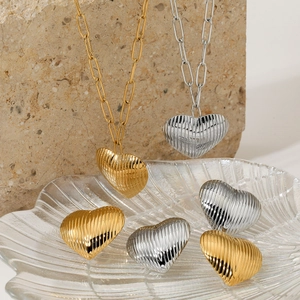 Textured heart pendant necklace set in gold and silver stainless steel finish
