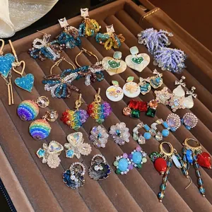 Boucles d'oreilles fleur en cristal et cœur géométrique sur plateau en velours marron