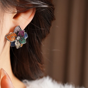 Macro side view of vintage flower stud earring with colorful zircon stones on model