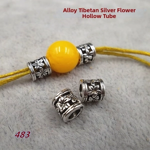 Macro detail of antique silver hollow tube beads with gardenia flower pattern for DIY jewelry