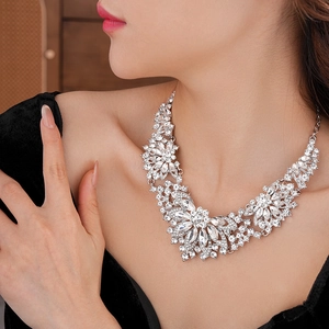 Close-up of sparkling floral pendant necklace with clear crystals on a female model