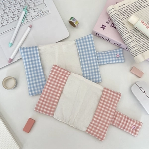 Blue and pink checkered fabric book covers in a cozy desk stationery scene setup