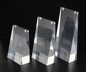 Three-piece clear acrylic necklace display stands with geometric wedge shape on dark base