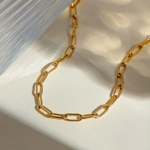Detail view of 18K gold plated rectangular link chain on a clean minimalist background