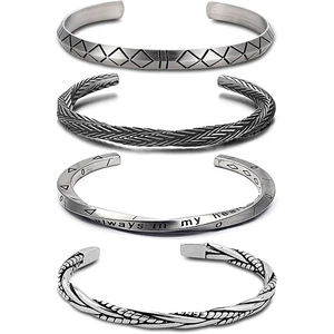 Detailed view of four antique silver Viking bracelets with geometric and braided patterns