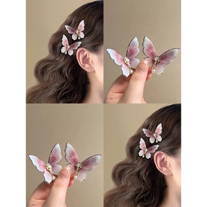 Elegant butterfly hair clips with pink gradient pearls and rhinestones shown on a model