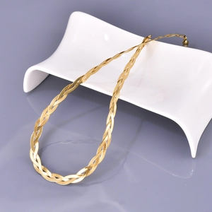 Detailed view of the woven triple-layer 18K gold snake chain necklace on white ceramic