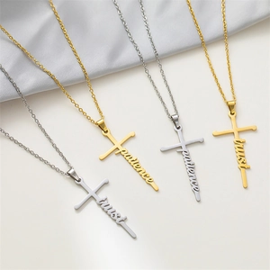 Detail of stainless steel cross necklaces with trust and patience word engravings