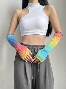 Detail view of rainbow gradient knit wool arm warmers worn by a model in a lifestyle setting