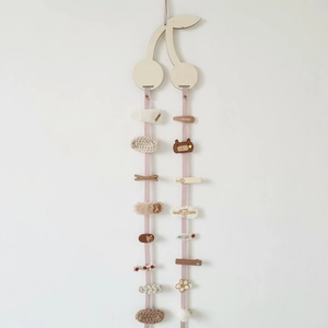 Detail of wooden cherry hair clip holder with pink ribbon for hanging kids' accessories