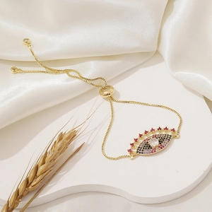 Macro detail of adjustable evil eye bracelet with colorful zircons on white silk