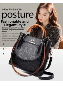 Detail of black embossed leather tote featuring orange handles and gold kangaroo logo
