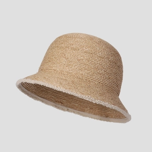 Detailed weave of natural raffia bucket hat featuring decorative white frayed edges