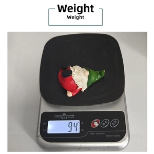 Detailed view of handmade Christmas gnome weight measuring 94g on a digital scale