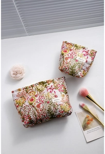 Floral jacquard cosmetic bags with colorful patterns and H&R BAG woven label in a flat lay