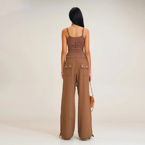 Detail of adjustable drawstring cuffs and cross motif on wide-leg cargo pants and vest set