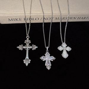Detail shot of three silver cross pendants with cubic zirconia and mother of pearl inlay