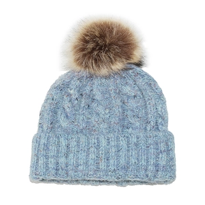 Close-up of the sky blue chunky cable knit beanie with a brown faux fur pom-pom detail