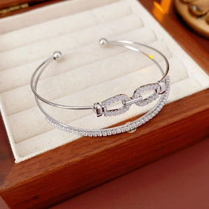 Détail d'un bracelet jonc double couche en argent avec zircons sur présentoir en velours