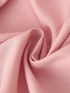 Close-up of pink fabric texture showing fine weave patterns and soft draped folds