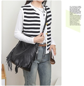 Mannequin portant un grand sac seau noir en cuir avec de longues franges bohèmes chic