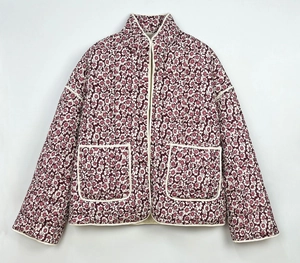 Detailed view of women's quilted floral jacket featuring stand collar and front patch pockets
