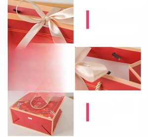 Detail of red floral gift bag with golden rope handles and reinforced base construction