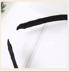 Detail of black ribbon-wrapped headband ends showing anti-slip texture and finish