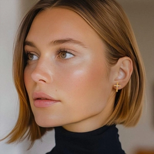 Golden cross earrings with round zirconia stone on model for a minimalist style