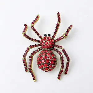 Detailed view of spider brooch with vibrant red crystals and golden alloy setting