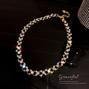 Collier élégant plaqué or avec perles blanches et diamants sur fond noir brillant raffiné