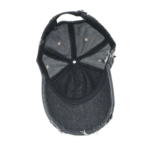 Detail view of washed denim baseball cap with distressed holes and adjustable metal buckle