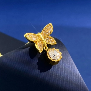 Detailed macro shot of a golden butterfly earring with sparkling diamonds and starburst light