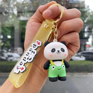 Close-up of cute cartoon panda keychain with green overalls and yellow panda wrist strap
