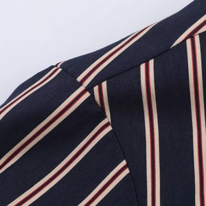 Detailed close-up of dark blue pinstripe blazer fabric with beige and red woven texture