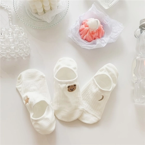 Detailed embroidery of brown bear, gold star, and moon patterns on white cotton socks