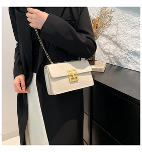 Detail of a beige chain shoulder bag with a gold geometric clasp and smooth leather finish